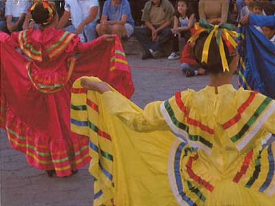 [Swirling red and yellow ribbon skirts and blouses of two dancers in the folkloric ballet, Alamos, Sonora, Mexico: 19k]