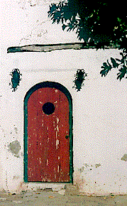 [Bright red arched door in white stuccoed wall: 24k]