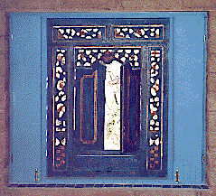 [Indondesian blue filigree shutters opening to the desert view: 29k]